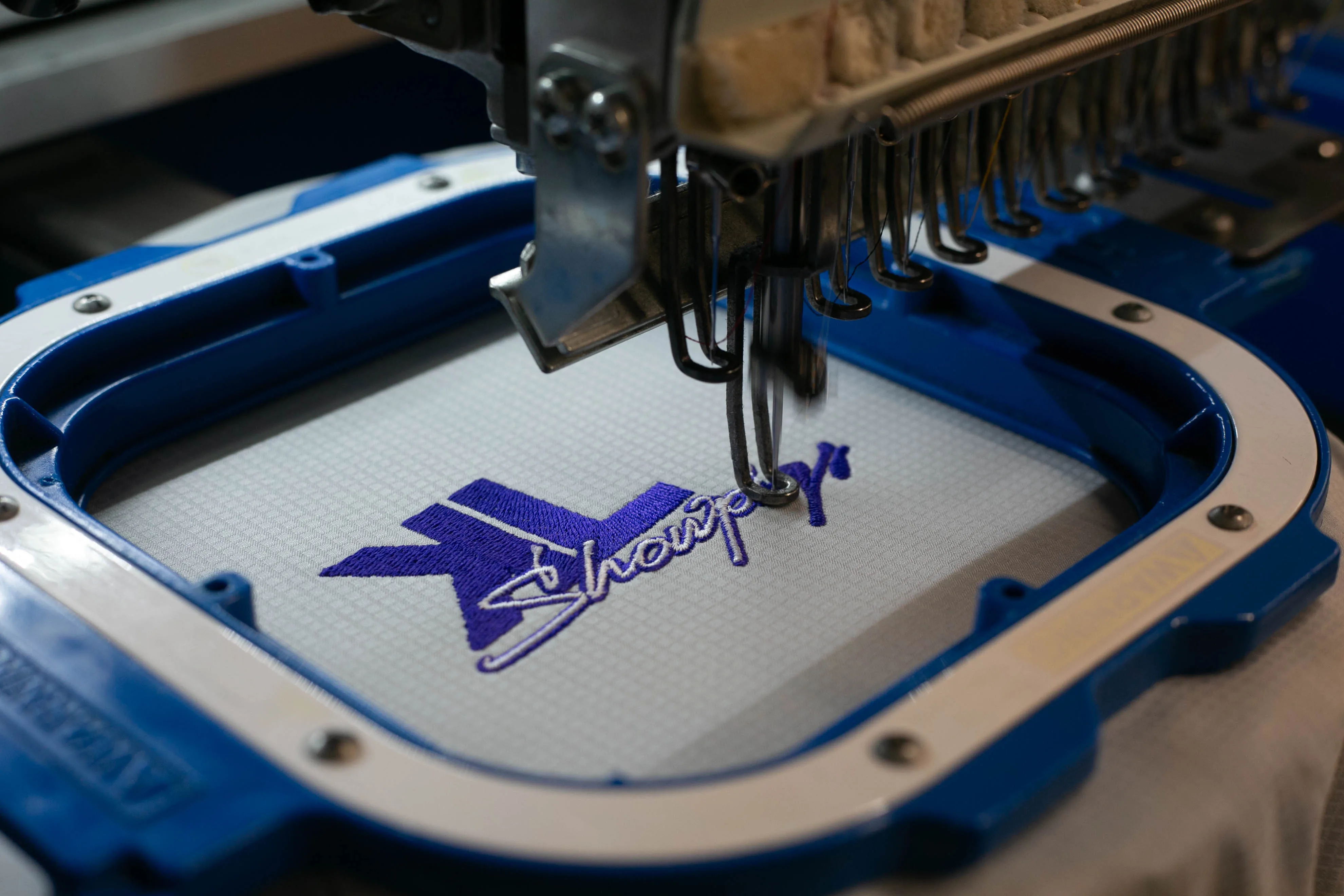 Embroidery machine stitching a logo